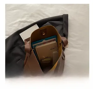 Detail showing high-capacity brown PU leather tote bag with metal magnetic closure