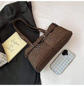 Close-up of a dark brown textured underarm bag with silver buckle and sleek straps