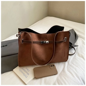 Close-up of caramel brown matte suede tote bag with silver metal swivel lock detail