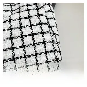 Detailed close-up of high-quality black and white checkered tweed fabric on a tote bag