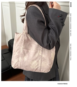 Close-up of pink canvas tote bag with white floral pattern and front exterior pocket