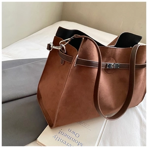 Macro detail of brown frosted suede tote bag with contrast leather strap and metal buckle