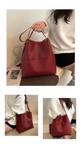 Detail view of large red matte leather bucket bag featuring front double pockets and straps