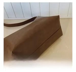Close-up of caramel brown leather tote bag showing soft matte texture and detail stitching