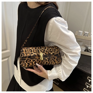 Detail of vintage leopard print shoulder bag featuring a round gold metallic buckle closure