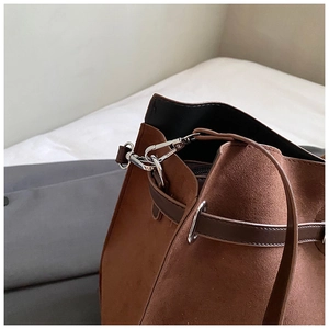Detail of vintage matte suede tote bag with brown leather straps and silver metal hardware