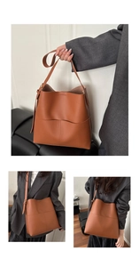 Detail of caramel brown leather bucket bag with front pocket and adjustable strap