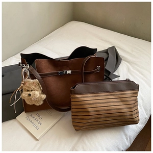 Detail of vintage brown suede tote and striped pouch set with cute dog charm