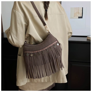 Detail of vintage suede shoulder bag with ethnic patterned webbing and long fringe
