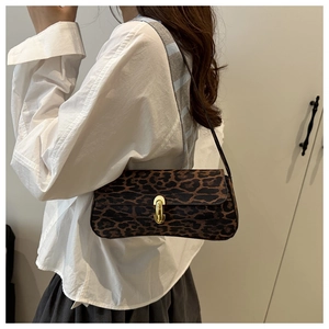Detailed view of leopard print crossbody bag featuring golden buckle and slim strap