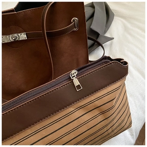 Detail of vintage matte brown tote and striped canvas bag with silver buckle and zipper