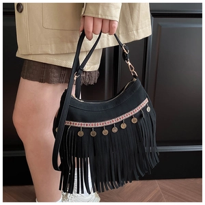 Detail of ethnic tassel bag with red embroidery, metal coins and leather strap