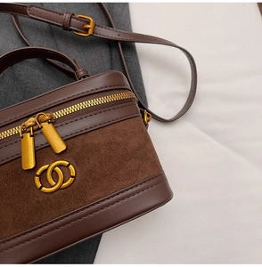 Detail of vintage brown vanity bag featuring mixed leather, suede, and matte gold hardware