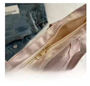 Detail of floral canvas tote bag with smooth gold metal zipper and pink flower pattern