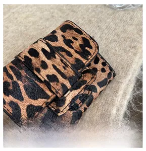 Close-up of leopard print leather card wallet with fine stitching on plush background