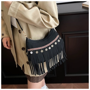 Detail of bohemian black fringe bag with ethnic embroidery and silver coin pendants