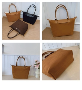 Detail view of large nylon tote bags showing leather handles and metal snap button flap