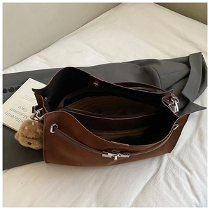 Interior detail of a brown faux suede tote bag featuring multi-compartment storage and lock