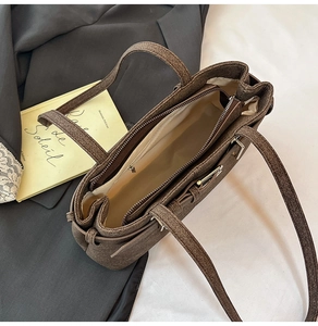Top view of brown woven tote bag interior showing multiple compartments and zipper detail