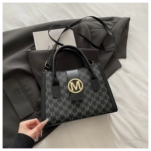 Borsa tote chic monogrammata con fibbia dorata logo M su blazer grigio e libro d'arte