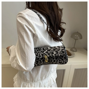 Detailed view of leopard print shoulder bag featuring a sleek golden metal clasp closure