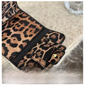 Detailed view of leopard print texture with precise black stitching and snap closure