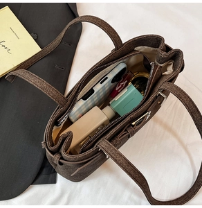 Detailed interior of a textured brown tote showing organized storage for essentials