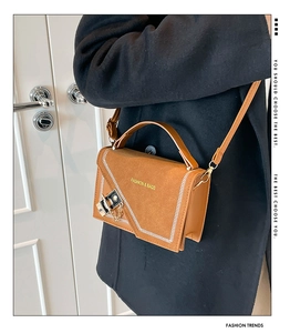 Detail of camel suede crossbody bag with contrast stitching and metal twist lock detail