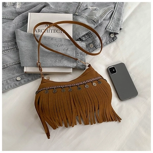 Detail view of brown bohemian fringe crossbody bag with ethnic weaving and coin charms