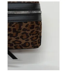 Détail du tissu en velours léopard avec bordure en cuir noir et fermeture éclair en métal