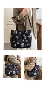 Close-up of black floral tote bag showing side pocket and long shoulder straps