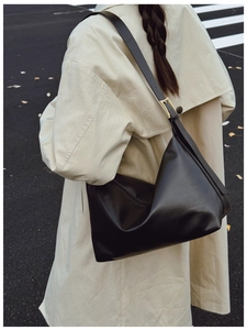 Detail of black matte leather hobo bag with adjustable strap and gold hardware