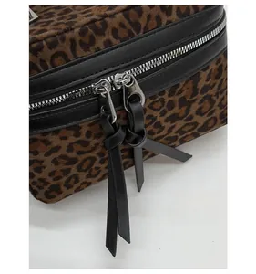Gros plan du sac seau léopard avec fermeture éclair en métal argenté et garniture en cuir