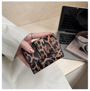 Close-up of leopard print mini card holder with textured finish and buckle closure