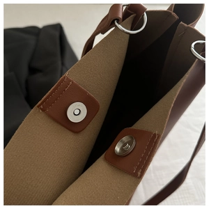 Close-up of brown tote bag interior featuring silver magnetic clasp and metal ring