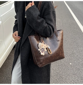 Macro detail of vintage brown leather tote bag texture with embossed brand logo