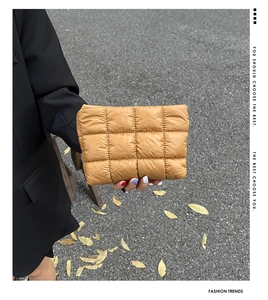 Detailed close-up of caramel quilted nylon clutch with square stitching pattern