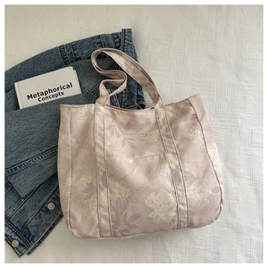 Detailed view of lavender floral tote bag with front pocket and sturdy canvas handles