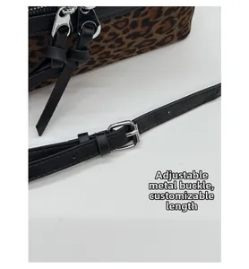 Détail de la boucle réglable en métal argenté sur un sac léopard avec sangle en cuir