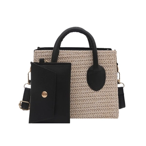 Fashionable beige straw woven tote bag with black leather handles and matching small pouch