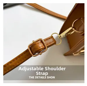 Detail of adjustable brown leather shoulder strap with gold-tone hardware buckles