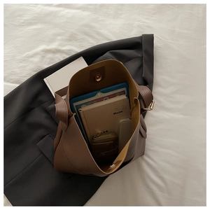 Flat lay view showing the large capacity of the brown bucket bag with daily essentials