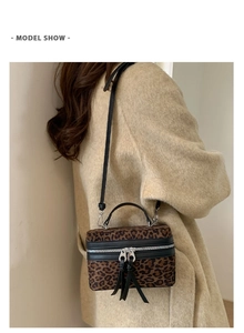Détail du sac boîte léopard avec double fermeture éclair argentée et texture peluche