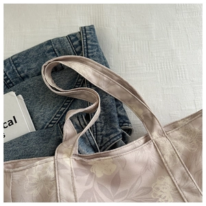 Detail of floral canvas tote bag showing double-stitch craftsmanship and soft print