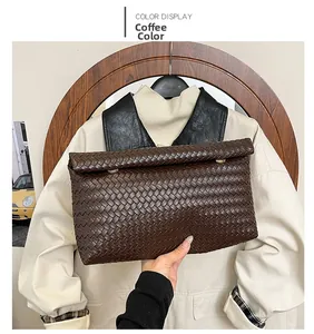 Dettaglio di pochette intrecciata color caffè con chiusura in metallo dorato circolare
