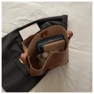Macro detail of brown leather tote bag interior showing large capacity and magnetic closure