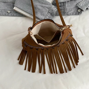 Detail view of brown tassel shoulder bag with ethnic woven patterns and interior pocket