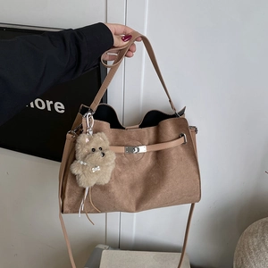 Brown frosted leather tote bag with plush bear charm and metallic buckle closure