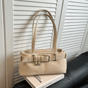 Elegant beige textured shoulder bag with metal buckle design in a minimalist still life setup