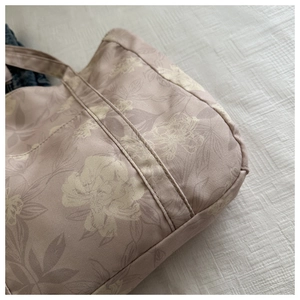 Detail of floral canvas tote bag showing fine stitching and vintage flower patterns